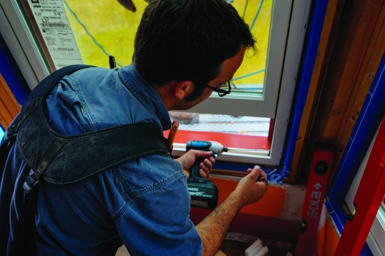 Pollard used long structural screws to pin the windows in place on the inside, splitting the difference to match the curved sill opening.
