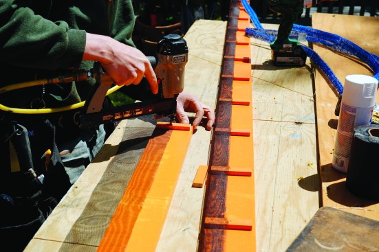 To prepare for siding, the crew installed trim and rainscreen fabric. They first applied spacers and screen to the back of the preprimed 3/4-inch pine trim.