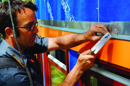 Then he nailed the pieces up above the window head trim, bending the zinc around the curve of the wall.