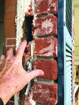 Inspection revealed that, in general, there was no intact drainage plane to be identified behind the existing brick, so the decision was made to isolate the replacement windows from the walls.