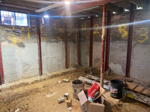 Vertical steel was added prevent the old brick and new concrete walls from hinging. The steel precluded the addition of a robust drainage matrix to the walls.