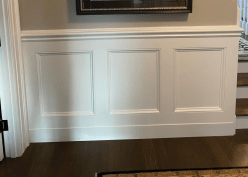 White paint finishes a traditional raised-panel wainscoting. This look is what most people think of as wainscoting but is nowhere near the only option for clients.
